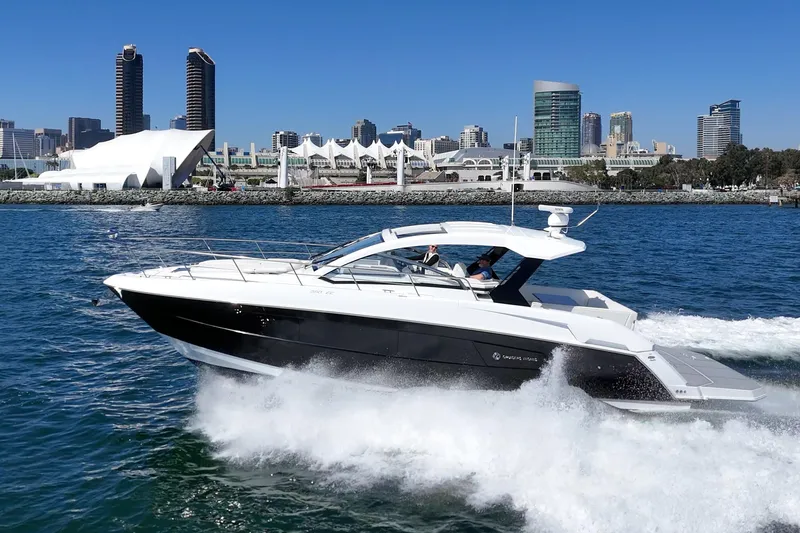 Slide: The Image of 2021 Cruisers Yachts 390 Express Coupe cruising near city skyline on a sunny day. - 20