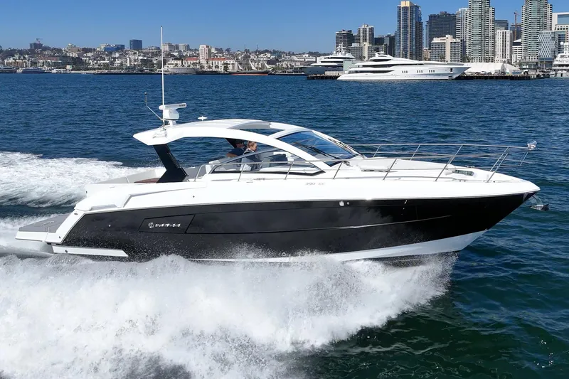 Slide: The Image of 2021 Cruisers Yachts 390 Express Coupe cruising on water with city skyline backdrop. - 22