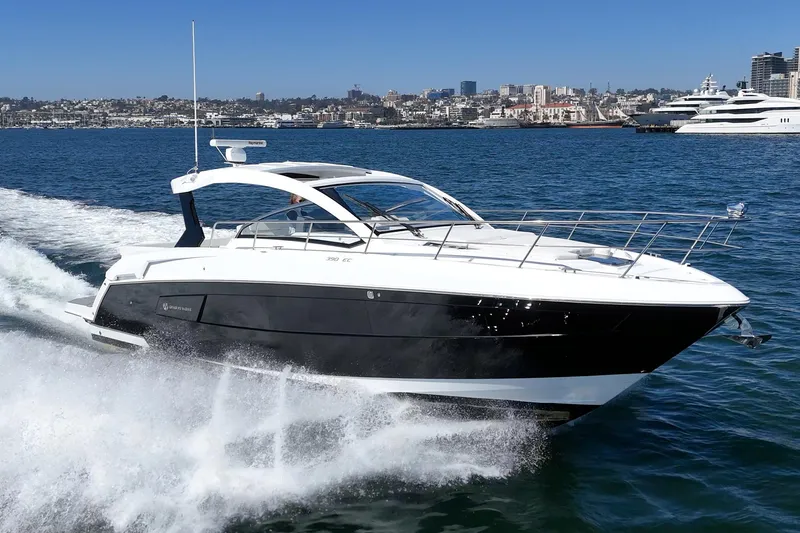 Slide: The Image of 2021 Cruisers Yachts 390 Express Coupe cruising on water, city skyline in background. - 23