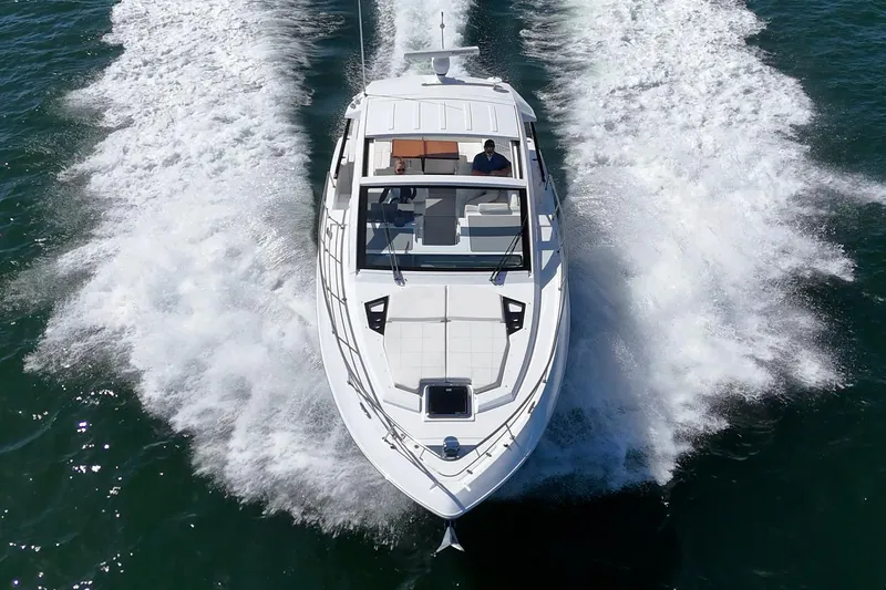 Slide: The Image of 2021 Cruisers Yachts 390 Express Coupe speeding on open water, aerial view. - 26