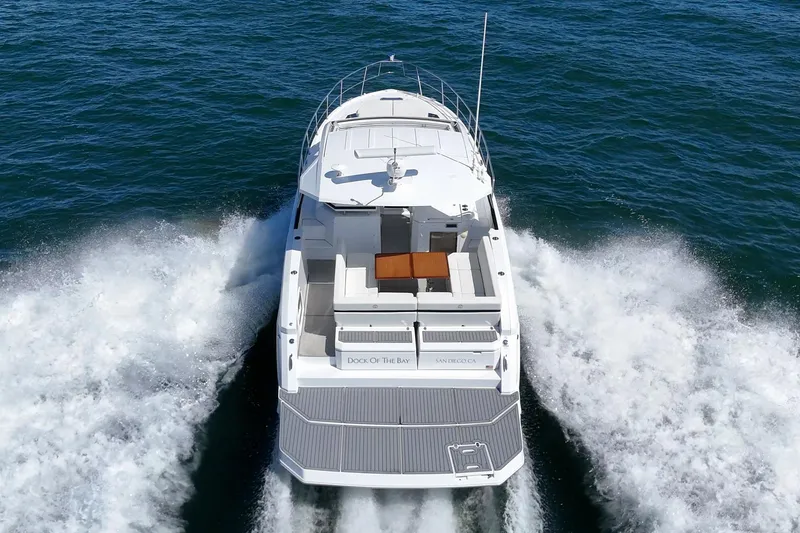 Slide: The Image of 2021 Cruisers Yachts 390 Express Coupe cruising on open water, rear view. - 28