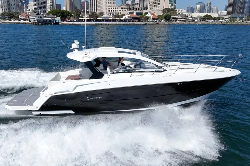 Slide: The Image of 2021 Cruisers Yachts 390 Express Coupe cruising on water near city skyline. - 29