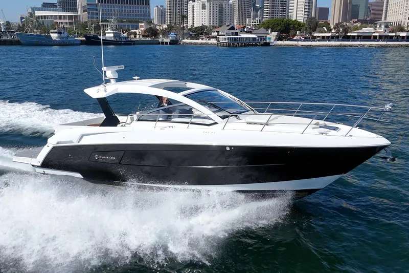 Slide: The Image of 2021 Cruisers Yachts 390 Express Coupe cruising on water near city skyline. - 30