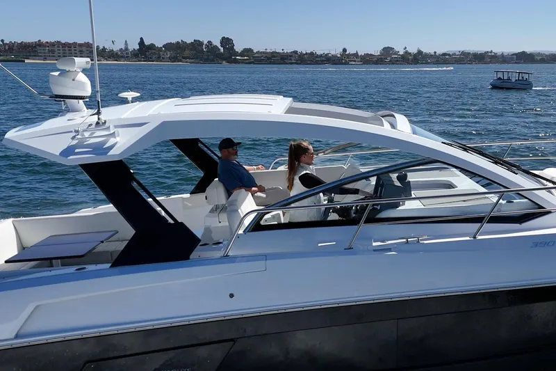 Slide: The Image of 2021 Cruisers Yachts 390 Express Coupe on water, two people onboard, sunny day. - 31