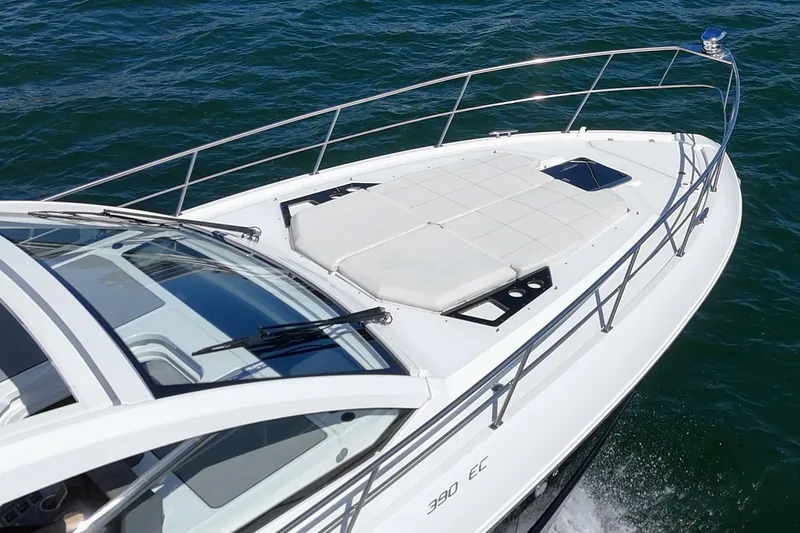 Slide: The Image of 2021 Cruisers Yachts 390 Express Coupe on water, showcasing sleek design and spacious deck. - 32