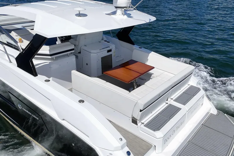 Slide: The Image of 2021 Cruisers Yachts 390 Express Coupe on water, featuring spacious deck and seating area. - 34