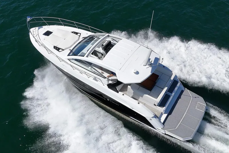 Slide: The Image of 2021 Cruisers Yachts 390 Express Coupe speeding on open water. - 4