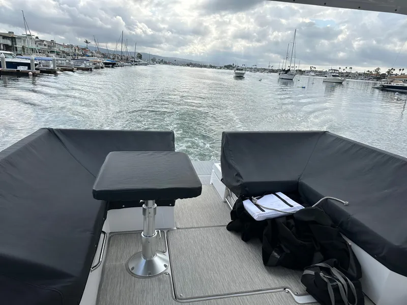 Slide: The Image of 2021 Cruisers Yachts 390 Express Coupe, rear view, open water, cloudy sky, marina backdrop. - 40
