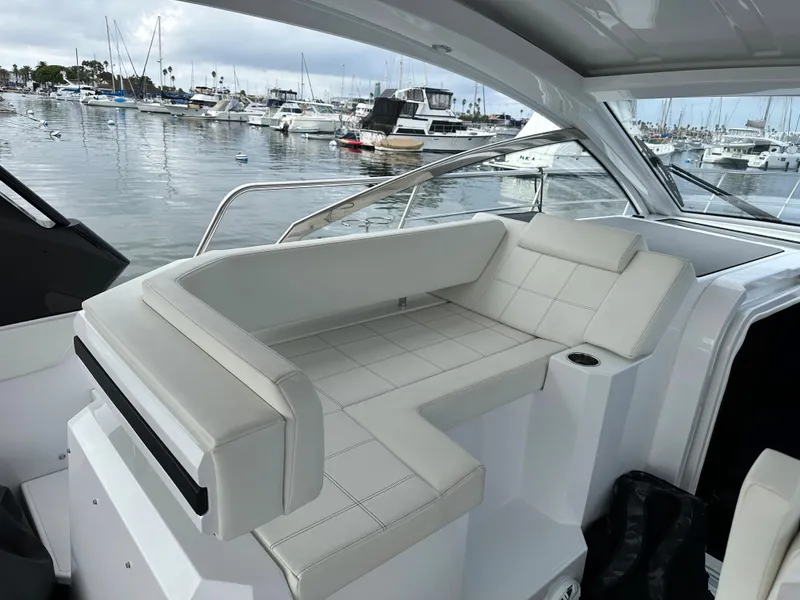 Slide: The Image of 2021 Cruisers Yachts 390 Express Coupe interior with white seating, docked at marina. - 42