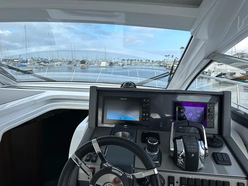 Slide: The Image of 2021 Cruisers Yachts 390 Express Coupe helm with marina view. - 48