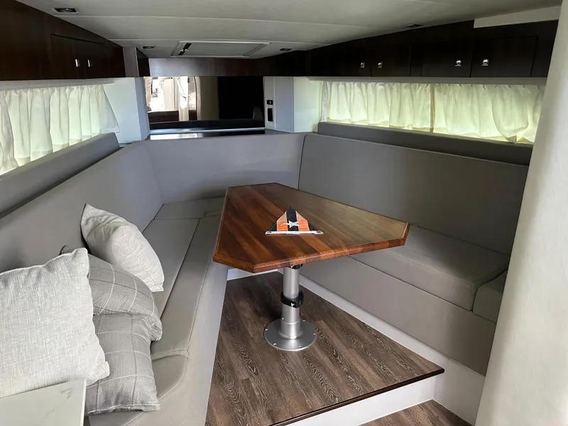 Slide: The Image of Interior of 2021 Cruisers Yachts 390 Express Coupe with modern seating and wooden table. - 50