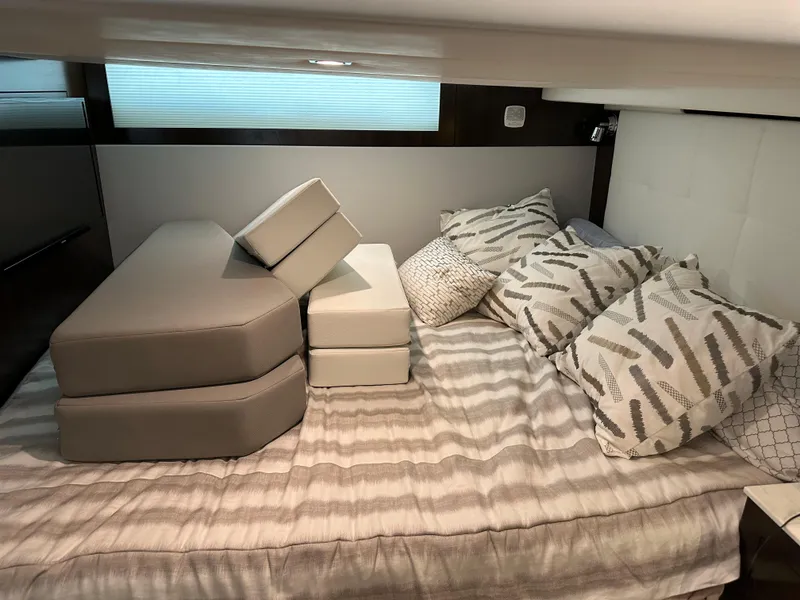 Slide: The Image of 2021 Cruisers Yachts 390 Express Coupe cabin with cushions and pillows on a bed. - 52