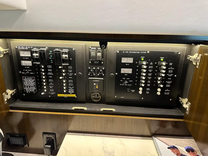 Slide: The Image of Electrical control panel inside 2021 Cruisers Yachts 390 Express Coupe, featuring switches and circuit breakers. - 53