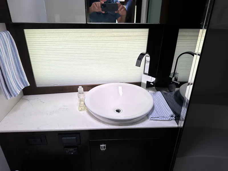 Slide: The Image of Modern bathroom sink in 2021 Cruisers Yachts 390 Express Coupe, featuring sleek design and accessories. - 54