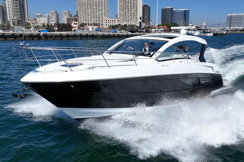 Slide: The Image of 2021 Cruisers Yachts 390 Express Coupe cruising on water near city skyline. - 9