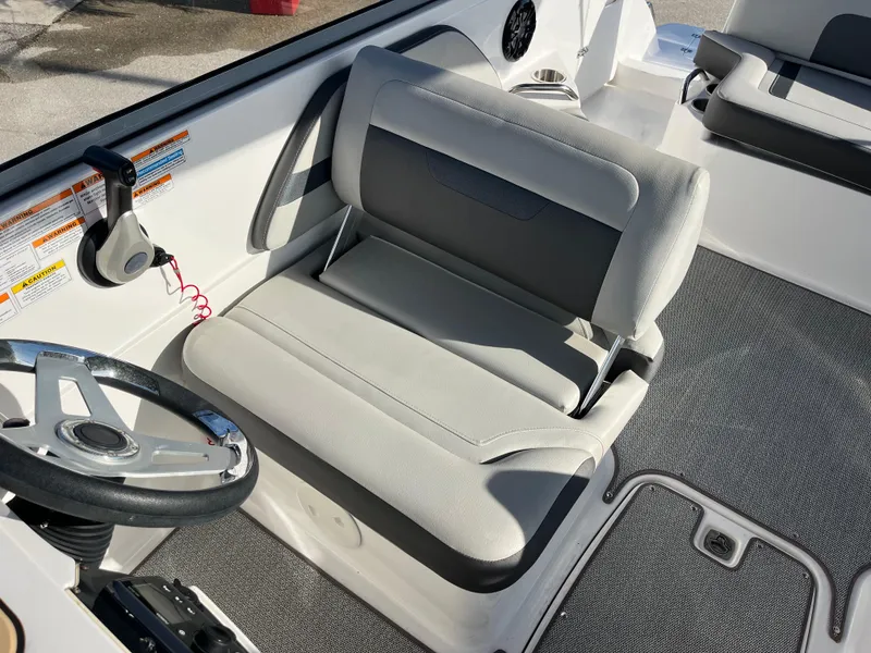 Slide: The Image of 2020 Hurricane SunDeck 235 OB boat interior with gray seating and steering wheel. - 16