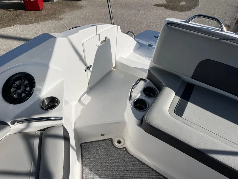 Slide: The Image of 2020 Hurricane SunDeck 235 OB interior with seating, cup holders, and storage compartment. - 19