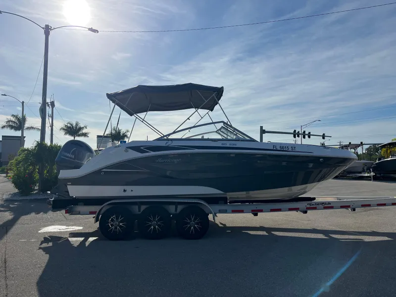 Slide: The Image of 2020 Hurricane SunDeck 235 OB boat on trailer, parked outdoors under clear sky. - 3