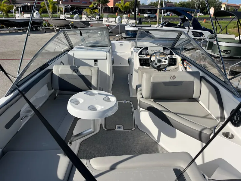 Slide: The Image of 2020 Hurricane SunDeck 235 OB boat interior with seating and steering wheel. - 8