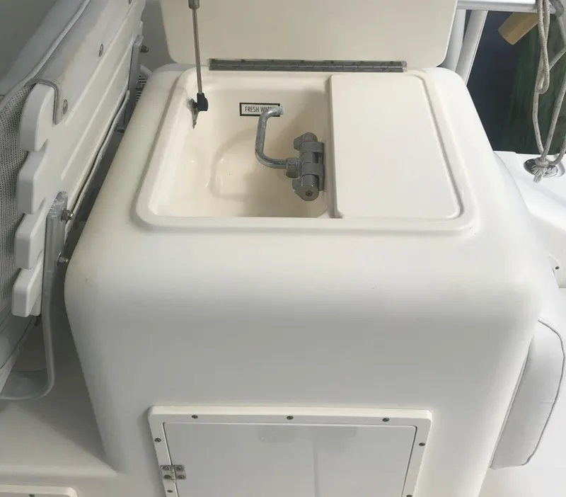 Slide: The Image of 2002 Pursuit 3000 Express boat sink with faucet and storage compartment. - 11