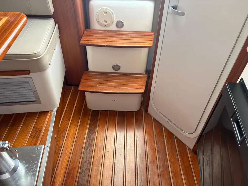 Slide: The Image of Interior of 2002 Pursuit 3000 Express boat with wooden flooring and steps. - 20