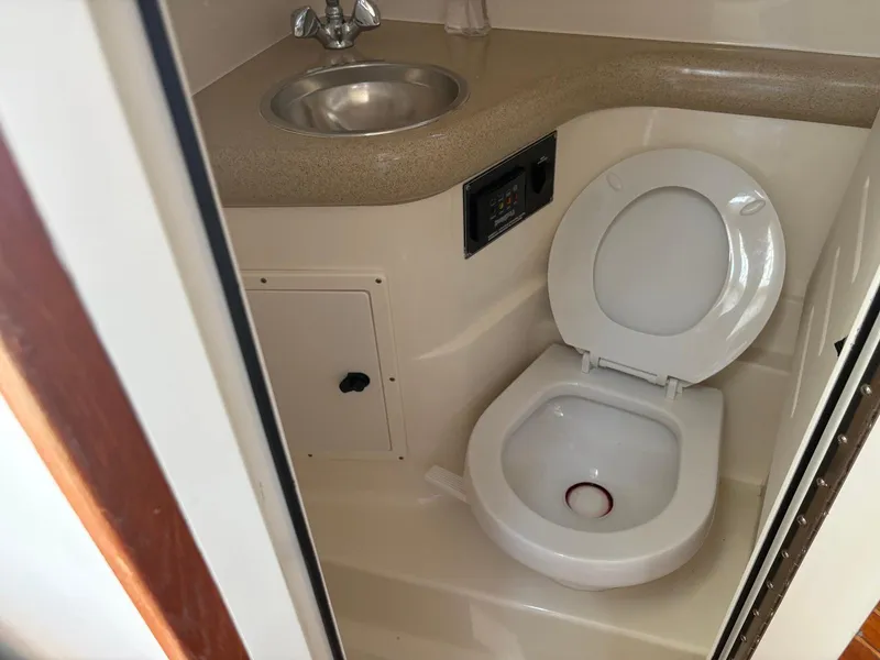 Slide: The Image of 2002 Pursuit 3000 Express boat bathroom with sink and toilet. - 24