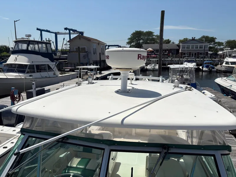 Slide: The Image of 2002 Pursuit 3000 Express boat docked at marina with radar equipment. - 3