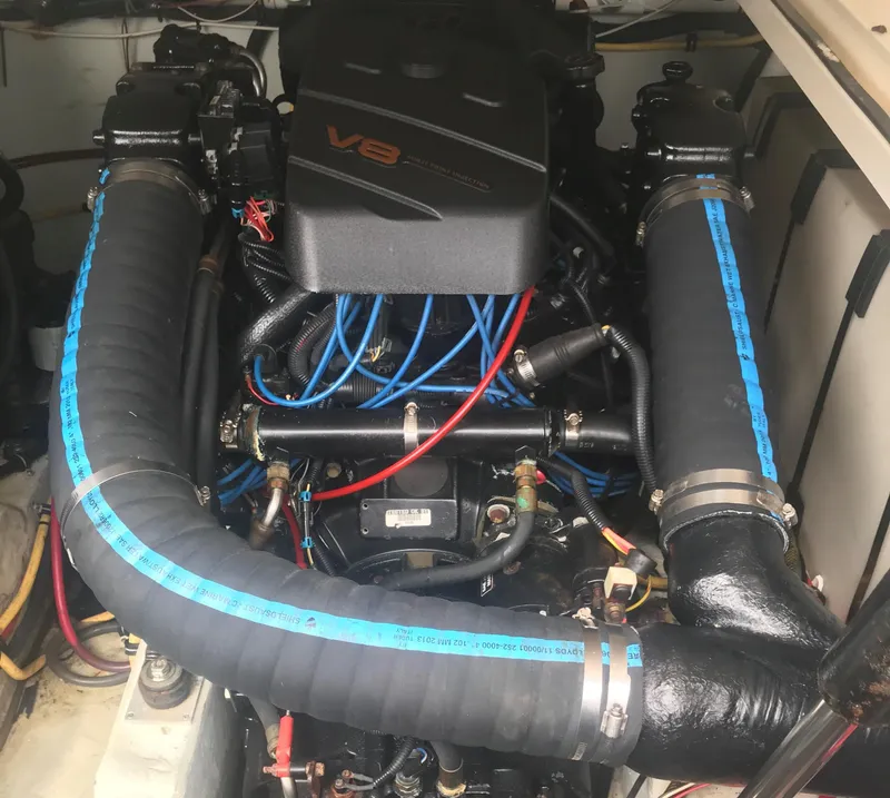 Slide: The Image of V8 engine of a 2002 Pursuit 3000 Express boat, featuring blue hoses and wiring. - 35