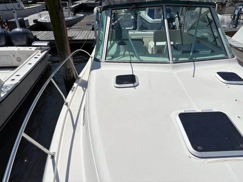Slide: The Image of 2002 Pursuit 3000 Express boat docked at marina, showing deck and windshield. - 4