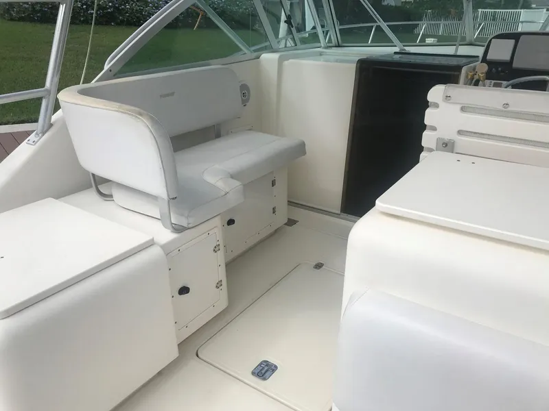 Slide: The Image of 2002 Pursuit 3000 Express boat interior with white seating and storage compartments. - 8