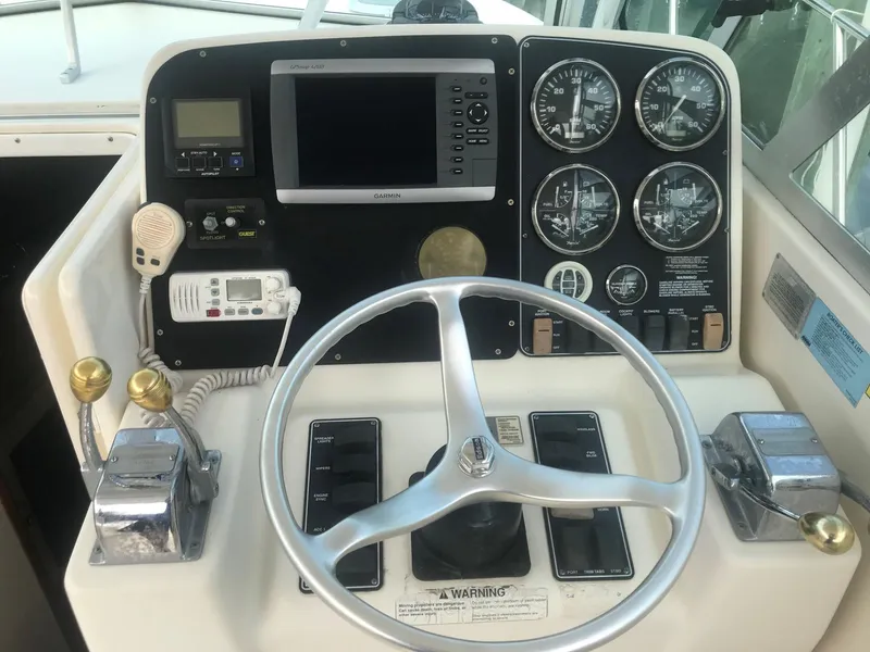 Slide: The Image of Helm of 2002 Pursuit 3000 Express boat with steering wheel and navigation instruments. - 9