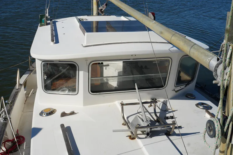 Slide: The Image of 1977 Fisher 37 MS sailboat deck with windows and rigging, docked on calm water. - 12