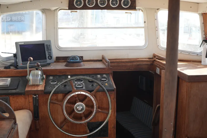 Slide: The Image of 1977 Fisher 37 MS boat interior with wooden helm, gauges, and navigation equipment. - 16