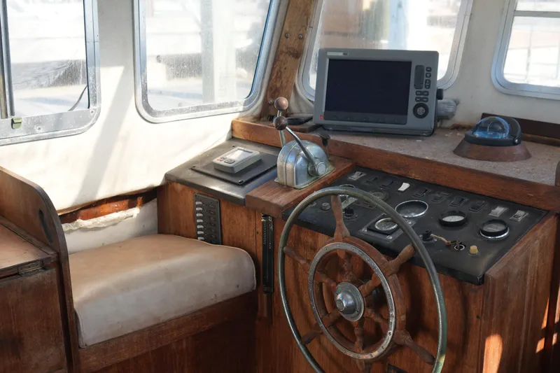 Slide: The Image of 1977 Fisher 37 MS boat cockpit with wooden steering wheel and navigation instruments. - 17