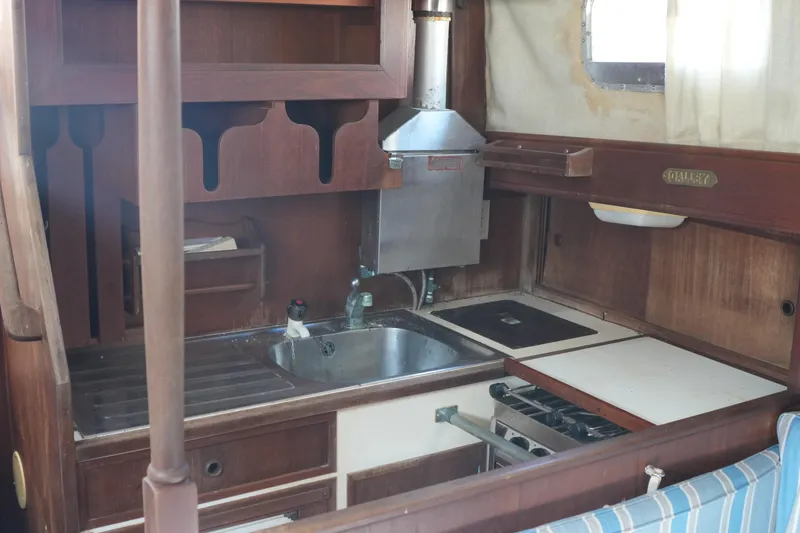 Slide: The Image of 1977 Fisher 37 MS yacht kitchen with wooden cabinetry and stainless steel sink. - 22