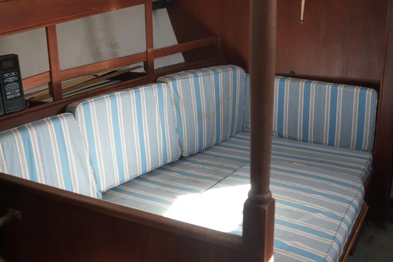 Slide: The Image of Interior of 1977 Fisher 37 MS with striped blue cushions and wooden paneling. - 25