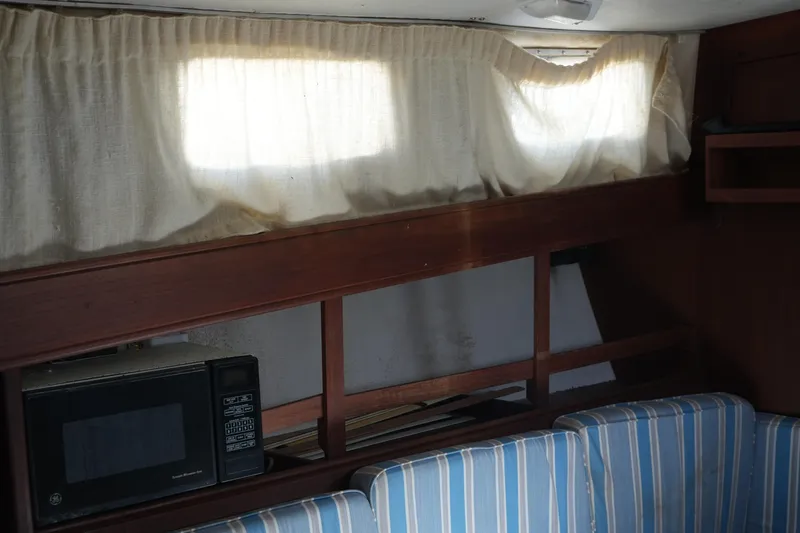 Slide: The Image of Interior of 1977 Fisher 37 MS boat with striped seating and microwave. - 26