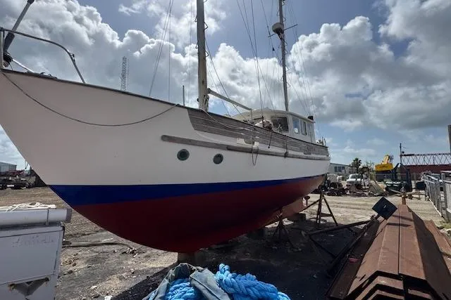Slide: The Image of 1977 Fisher 37 MS sailboat on dry dock under a cloudy sky. - 3