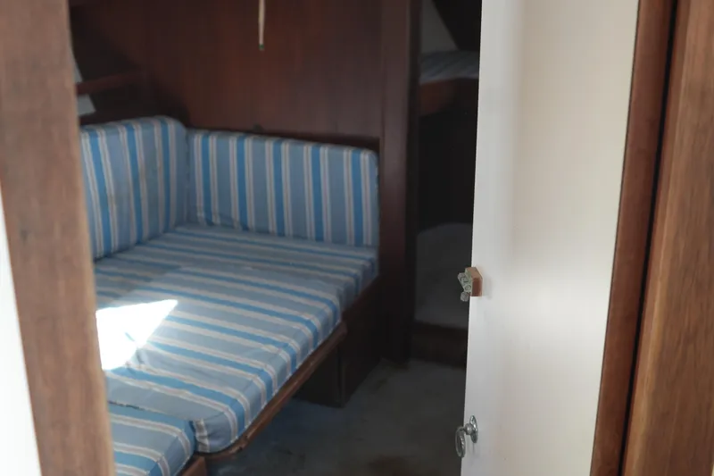 Slide: The Image of Interior of 1977 Fisher 37 MS sailboat with striped seating and wooden accents. - 31