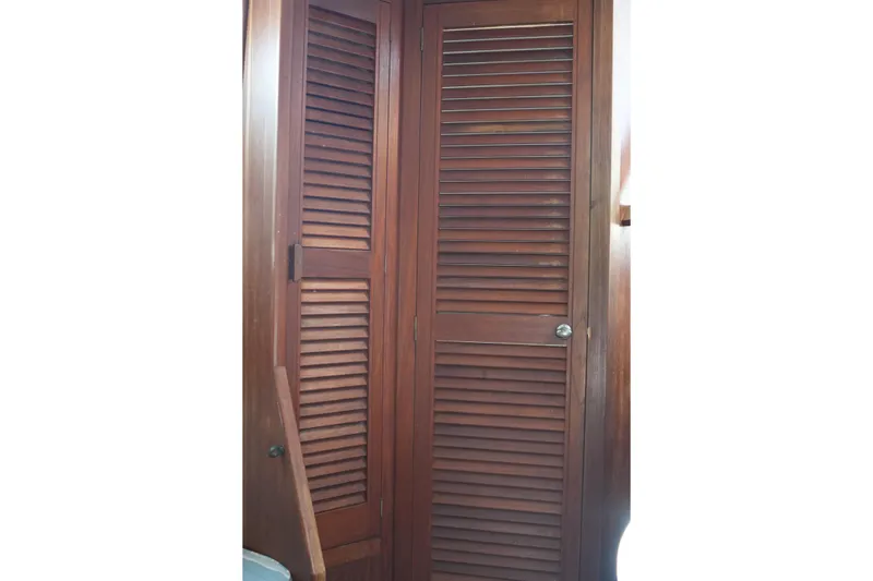 Slide: The Image of Wooden louvered door inside a 1977 Fisher 37 MS boat cabin. - 32