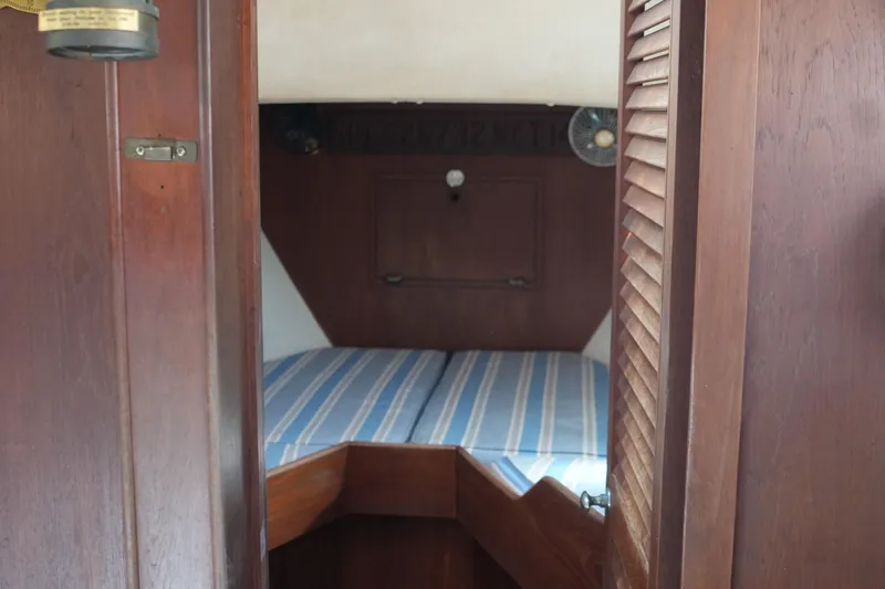 Slide: The Image of Cozy cabin interior of 1977 Fisher 37 MS sailboat with striped bedding. - 33