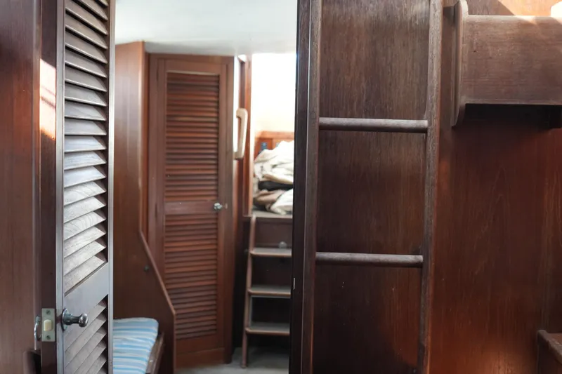Slide: The Image of Interior of 1977 Fisher 37 MS sailboat with wooden paneling and ladder. - 34