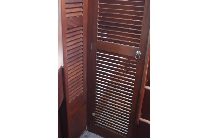 Slide: The Image of Wooden louvered door inside a 1977 Fisher 37 MS boat cabin. - 38