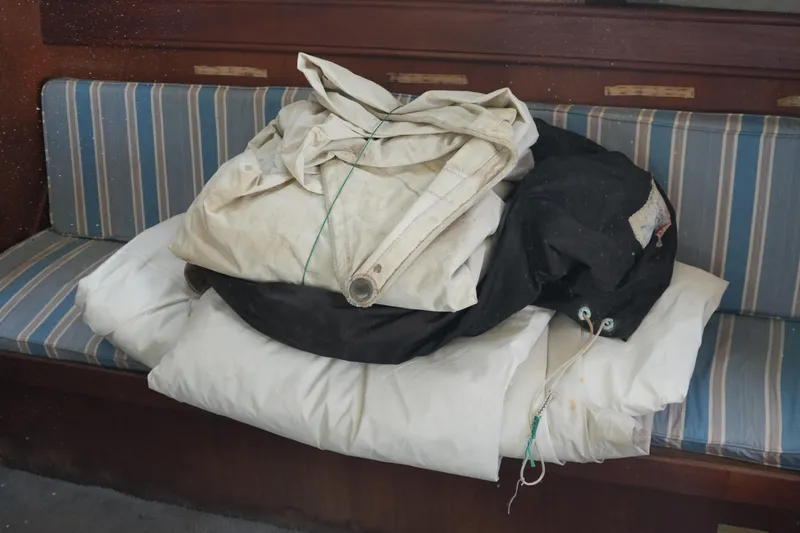 Slide: The Image of Folded sails on striped bench inside 1977 Fisher 37 MS boat cabin. - 39