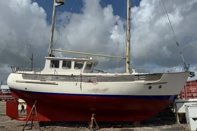 Slide: The Image of 1977 Fisher 37 MS sailboat on dry dock under cloudy sky. - 4