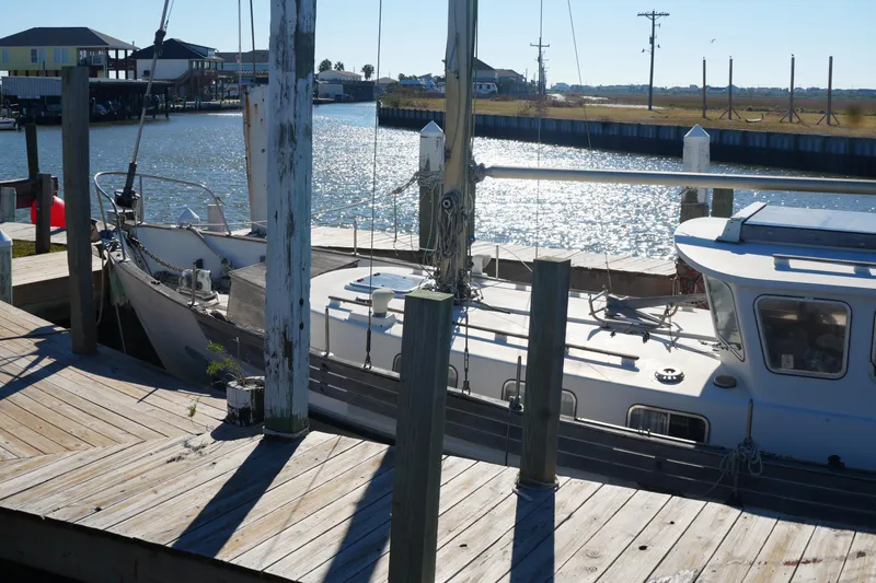 Slide: The Image of 1977 Fisher 37 MS sailboat docked by a sunny waterfront. - 8