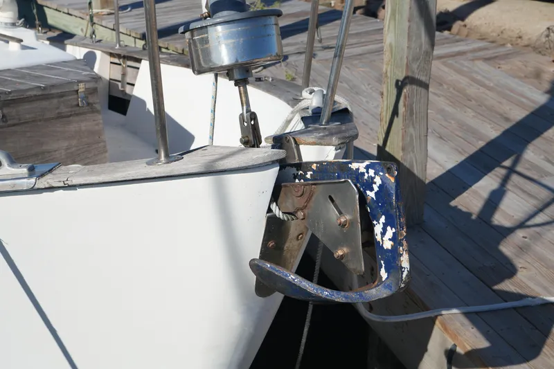 Slide: The Image of 1977 Fisher 37 MS boat anchor detail at dock, showing weathered paint and metal components. - 9