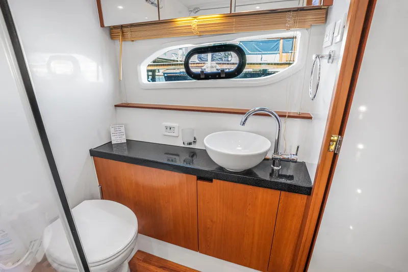Slide: The Image of Luxurious bathroom in 2017 Aquila 44 Yacht with modern sink and wooden cabinetry. - 29