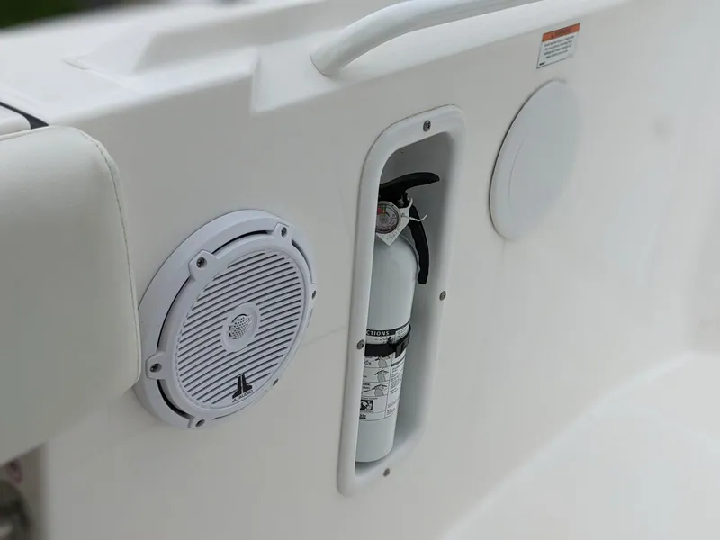 Slide: The Image of 2021 Edgewater 262 CC boat interior with speaker and fire extinguisher compartment. - 21