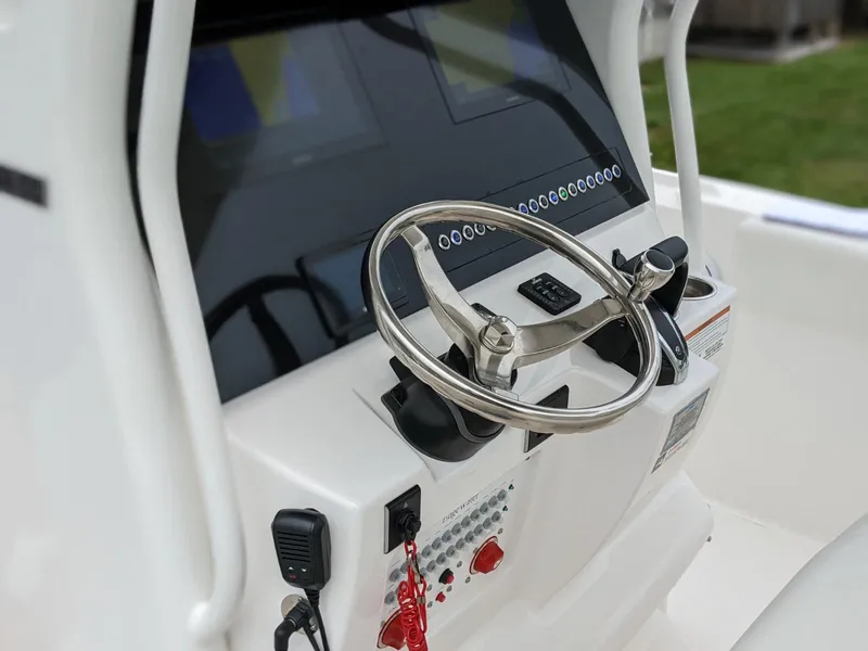 Slide: The Image of 2021 Edgewater 262 CC boat console with steering wheel and control panel. - 6